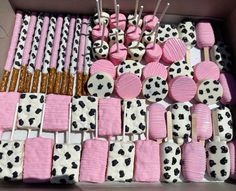 a box filled with lots of pink and black cake pops