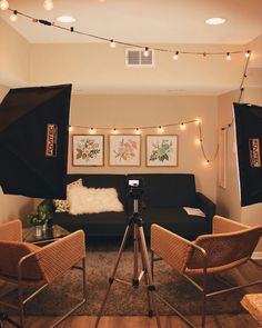 a camera set up in front of a couch with lights on the wall behind it