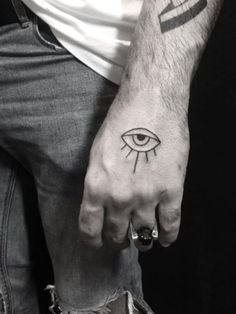 a man's hand with an eye tattoo on it