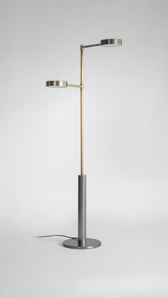 a lamp that is on top of a metal pole with two lights attached to it