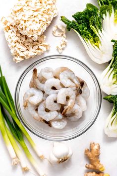 the ingredients to make shrimp and garlic soup are displayed on a white surface, including broccoli