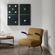 a chair and table in a room with two paintings on the wall