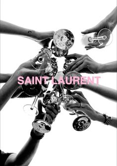 several hands holding wine glasses with the words saint laurent in pink and black on it