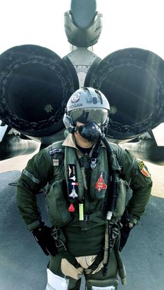 an air force pilot standing in front of a fighter jet