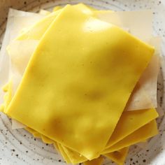 four pieces of yellow cake sitting on top of a white and brown plate with paper