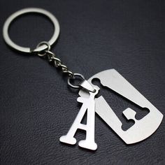 a metal keychain with a gas pump on it's front and side