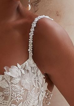 the back of a woman's wedding dress with pearls and beads on her neck