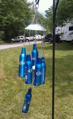 several blue soda bottles hanging from a metal pole with chains attached to the top and bottom