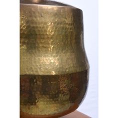 a gold vase sitting on top of a wooden table