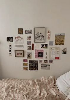 a bed sitting under a wall covered in pictures