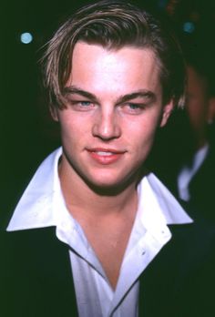 a young man wearing a black jacket and white shirt