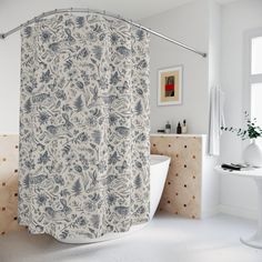 a bathroom with a bathtub, sink and shower curtain that has blue flowers on it