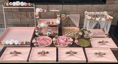 a table topped with lots of pink plates covered in flowers