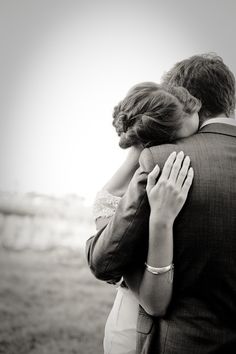 a man and woman hugging each other in black and white