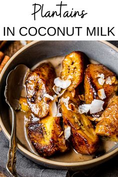 a bowl filled with bananas covered in coconut milk and sitting on a table next to cinnamon sticks