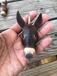 a hand holding a miniature donkey head in it's palm