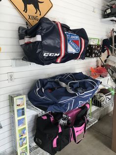 several sports bags are stacked on shelves in a garage