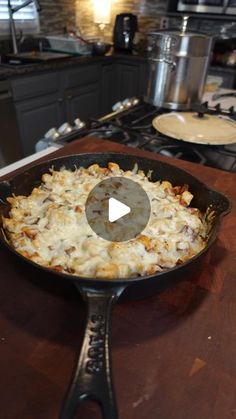 a skillet filled with food on top of a wooden counter