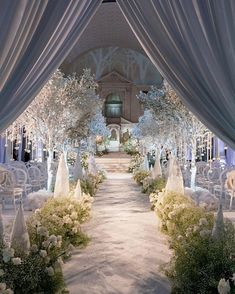 an outdoor wedding venue with white flowers and trees