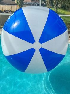 a large blue and white beach ball floating in a pool