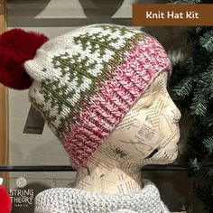 a knitted hat with pom - poms on top of a mannequin head