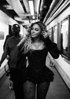 a black and white photo of a woman in a corset on the subway