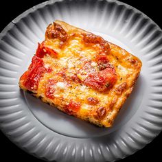 a piece of pizza sitting on top of a white plate