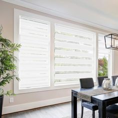 a dining room table and chairs with blinds on the windows