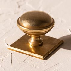 an antique brass door knob on a white brick wall in the afternoon sun, closeup