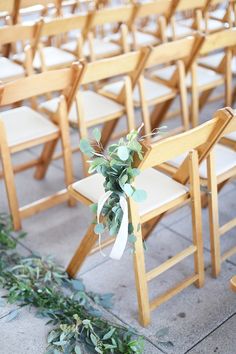 a row of wooden chairs sitting next to each other on top of a cement floor