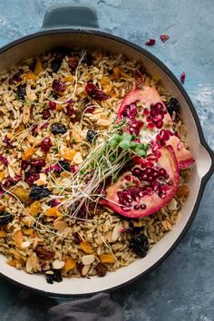 a bowl filled with rice and fruit on top of a wooden table