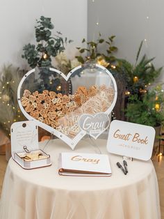 a table topped with a heart shaped sign and other personalized items next to a christmas tree