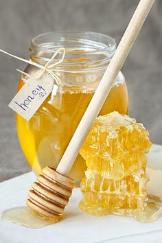 a jar of honey and a wooden stick