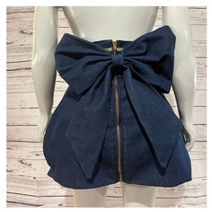 "This fun twist on your denim skirt features a high waistband trimmed with metallic gold bias tape, a mini tulip shaped bottom and is finished off with a large center back bow to add a bit of high fashion drama. From waist to hem the skirt measures 20\" long PLEASE view size chart provided before placing your order" Chic High Waist Denim Blue Mini Skirt, Chic Denim Skirt For Party, Chic High Waist Denim Blue Skort, Fitted Denim Skirt For Party, Chic Fitted Denim Skirt For Party, Denim Mini Bottoms For Party, High Waist Denim Skirt For Night Out, High Waist Denim Skirt, Skirt With Bow