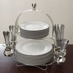 a stack of plates and silverware sitting on top of a wooden table