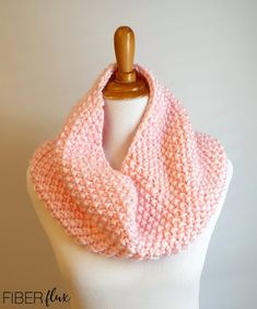 a white mannequin wearing a pink knitted cowl