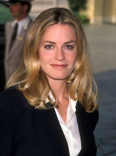 a woman with blonde hair wearing a black blazer and white shirt