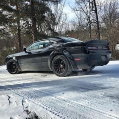 a black sports car is parked in the snow