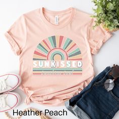 Step into a world of endless sunshine and tropical bliss with our Sunkissed T-Shirt. This vibrant design captures the essence of summer with its retro colors, accompanied by the word " Sunkissed". Immerse yourself in the nostalgic charm of the design as it transports you to a dreamy paradise filled with palm trees, clear blue skies, and pristine beaches. The soothing pastel palette adds a touch of vintage allure, evoking a sense of relaxation and carefree joy. Crafted with the utmost comfort in Soft-washed Multicolor Tops For Summer, Multicolor Text Print Summer Shirt, Trendy Multicolor T-shirt For Beach Season, Soft-washed Multicolor Summer Tops, Summer Soft-washed Graphic Tee Shirt, Retro Multicolor T-shirt For Vacation, Playful Short Sleeve T-shirt For Beach Season, Retro Relaxed Fit T-shirt For Beach, Summer Graphic Print T-shirt For Beach Season