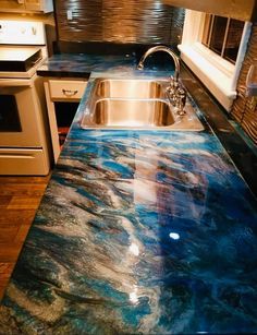 a kitchen counter with blue marble on the top and silver faucet above it