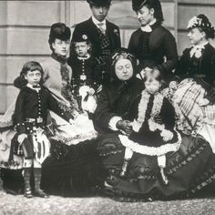 an old black and white photo of people dressed in victorian clothing, including young children