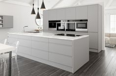 a modern kitchen with white cabinets and wood flooring