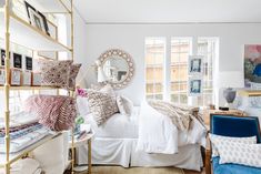 a bed room with a neatly made bed and lots of pillows