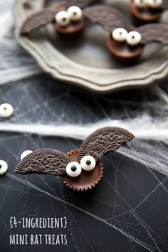 chocolate bats decorated with googly eyes on top of a plate