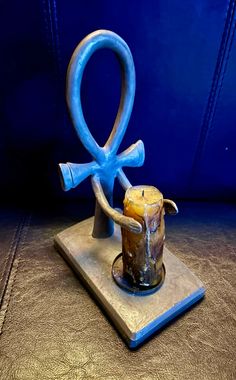 an egyptian symbol is displayed on a wooden stand with blue leather up to it's sides