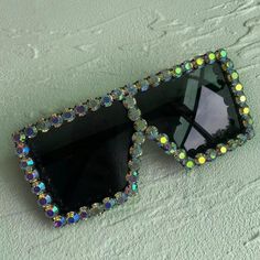 Glitzy Rhinestone Square Sunglasses with UV Protection Elevate your style game with our Glitzy Rhinestone Square Sunglasses. These oversized sunglasses feature dazzling rhinestone decoration, adding a touch of glamour to any outfit. Unmatched Style and Protection Perfect for parties and events, these sunglasses not only enhance your look but also protect your eyes from harmful UV rays. Frame Material: Polycarbonate Lenses Material: Acrylic Lenses Optical Attribute: UV400 Lens Height: 64mm Lens W Trendy Crystal Sunglasses With Rhinestones, Trendy Rhinestone Crystal Sunglasses, Trendy Bling Sunglasses With Glass Material, Trendy Bling Sunglasses With Glass, Trendy Bling Sunglasses With Glass Lenses, Party Sunglasses With Rhinestones And Crystal Material, Party Crystal Sunglasses With Rhinestones, Party Sunglasses With Bling And Glass Material, Trendy Silver Sunglasses With Rhinestones