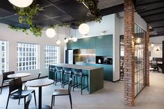 an open concept office with brick walls and exposed ceilings, bar stools, and tables