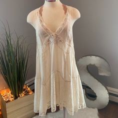 Intimately Free People Lace Off-White Dress Has A Deep V-Neck Cut With See Through Lace At The Top With The Bottom Lace Having An Underlay. Bralette Sold Separately. 70s Lace Dress, Summer Mini Dress With Lace Trim And V-neck, White V-neck Boho Summer Dress, Elegant White V-neck Boho Dress, Flowy V-neck Boho Dress With Lace Trim, Flowy V-neck Sundress With Lace Trim, Feminine White V-neck Beach Dress, V-neck Boho Dress With Lace Trim For Vacation, Boho V-neck Lace Trim Dress For Vacation