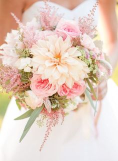 a bridal holding a bouquet of pink and white flowers