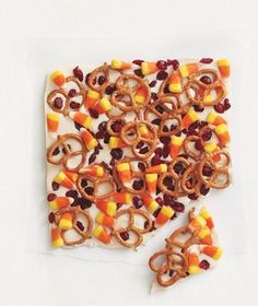 a square shaped plate filled with candy corn and pretzels on top of it